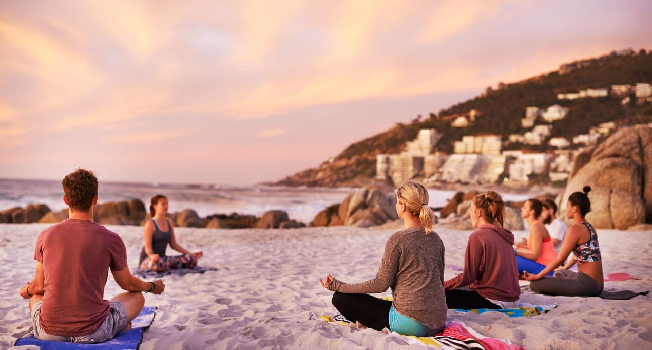 Yoga Gruppe am Strand während einer Meditation